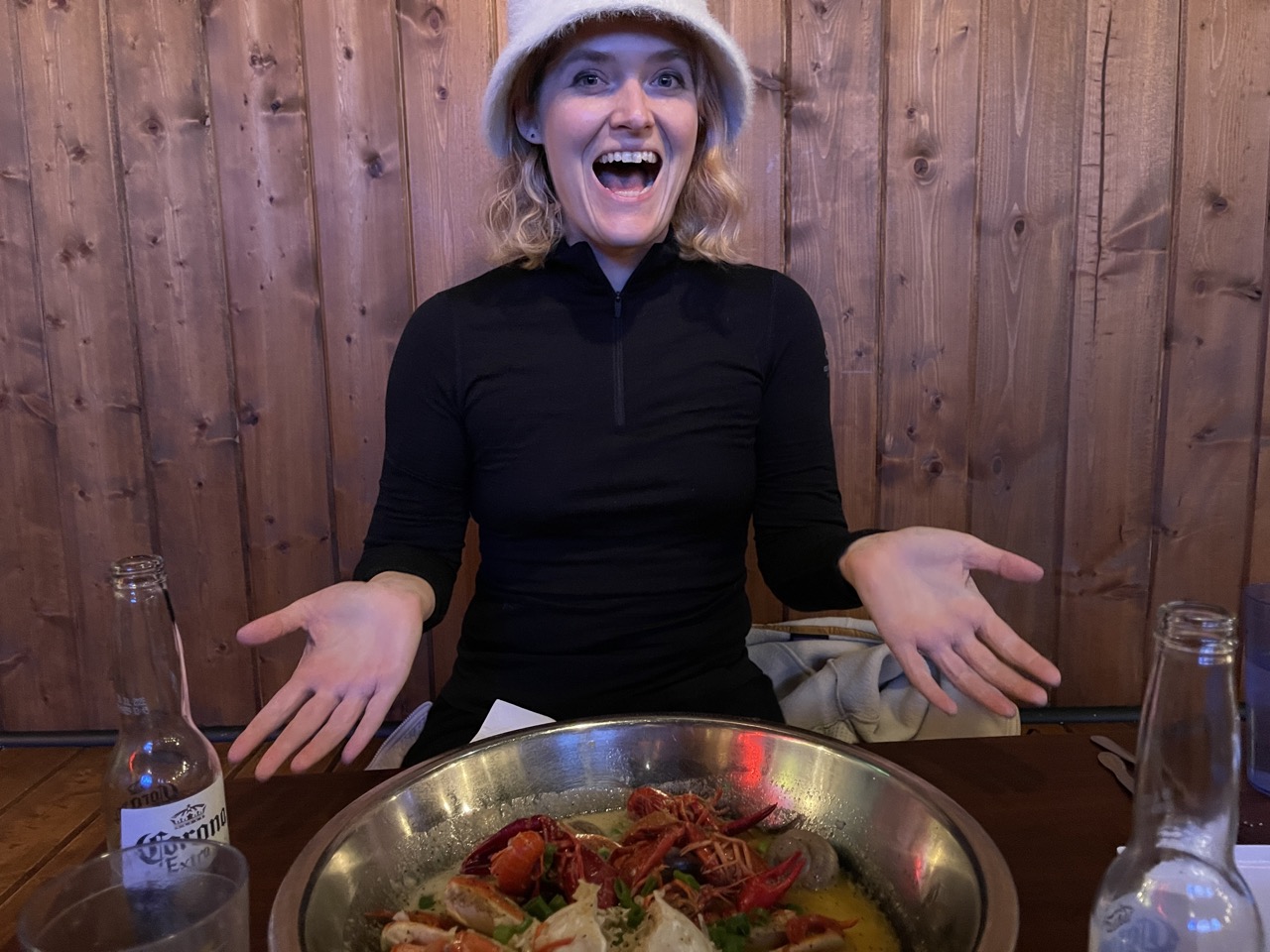 A person laughing in a bucket hat in a crayfish restaurant.